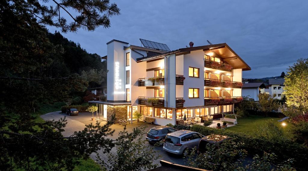 un edificio con dos coches estacionados en un estacionamiento en Gästehaus Rottenspacher, en Kössen