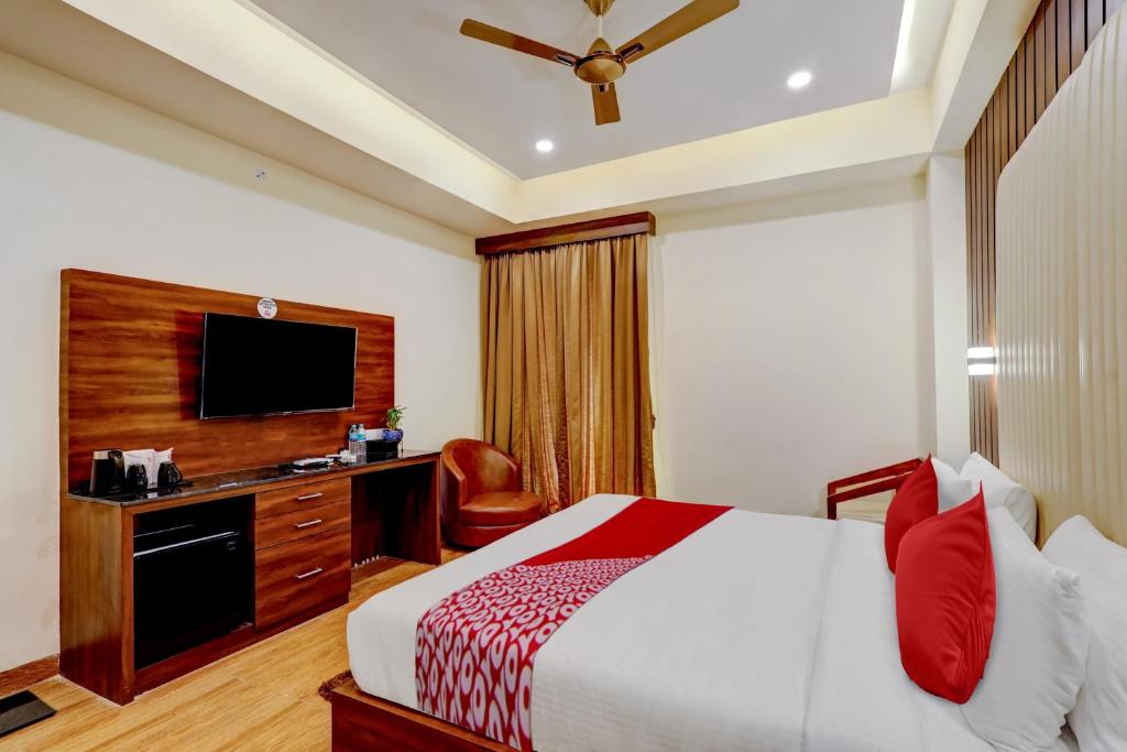 una camera d'albergo con letto e TV di OYO SAI GRAND LUXURY ROOMS a Tirupati
