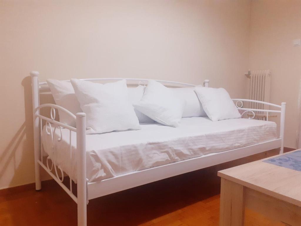 Una cama blanca con almohadas blancas. en A-Apartments -- Agiou Therapontos, en Atenas