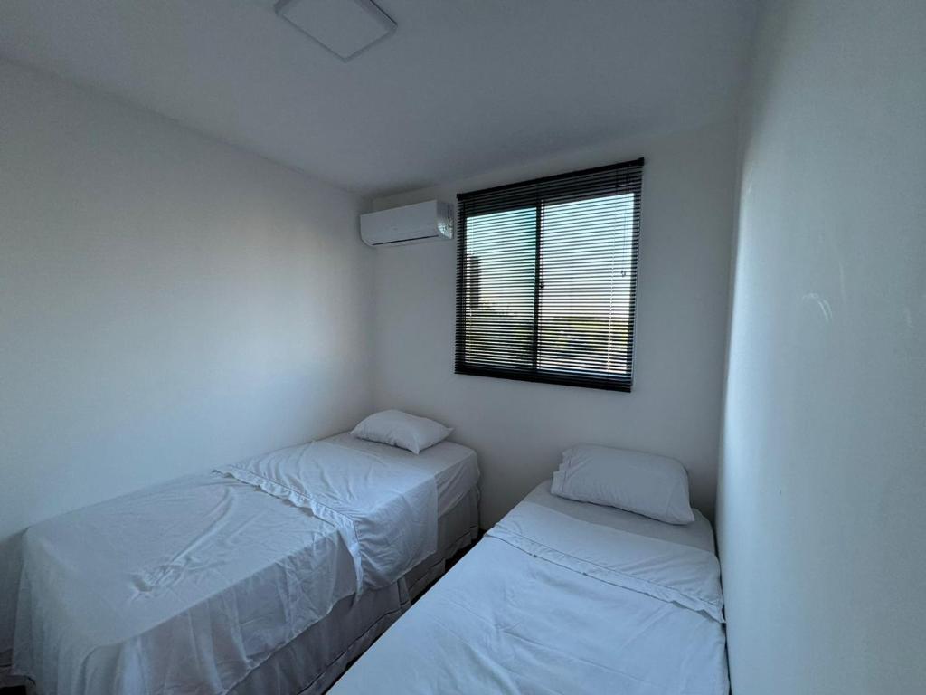 クイアバにあるConforto para até 4 Pessoasの窓のある小さな部屋にベッドが2つある