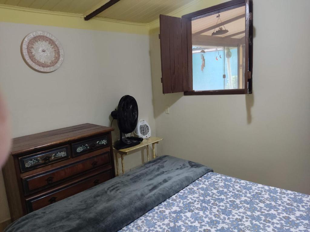 a bedroom with a bed and a dresser and a mirror at Chácara Toca da Zuca in Divino de São Lourenço