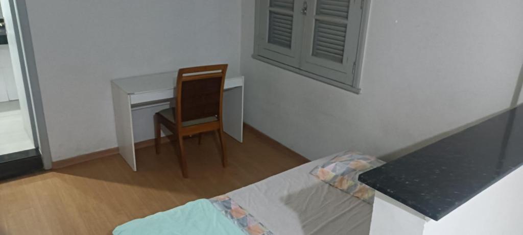 um pequeno quarto com uma secretária e uma cadeira em Suíte no centro de Belo Horizonte em Belo Horizonte
