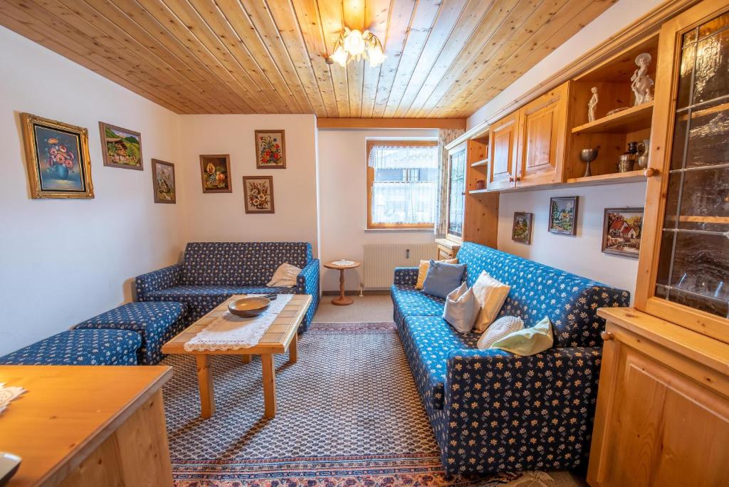 a living room with two blue couches and a table at Chalet Alpine Royal A Top 2 in Krimml