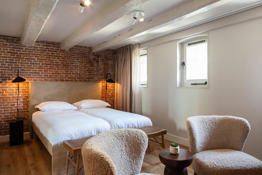a bedroom with two beds and two chairs at Storehouse Studios in Amsterdam