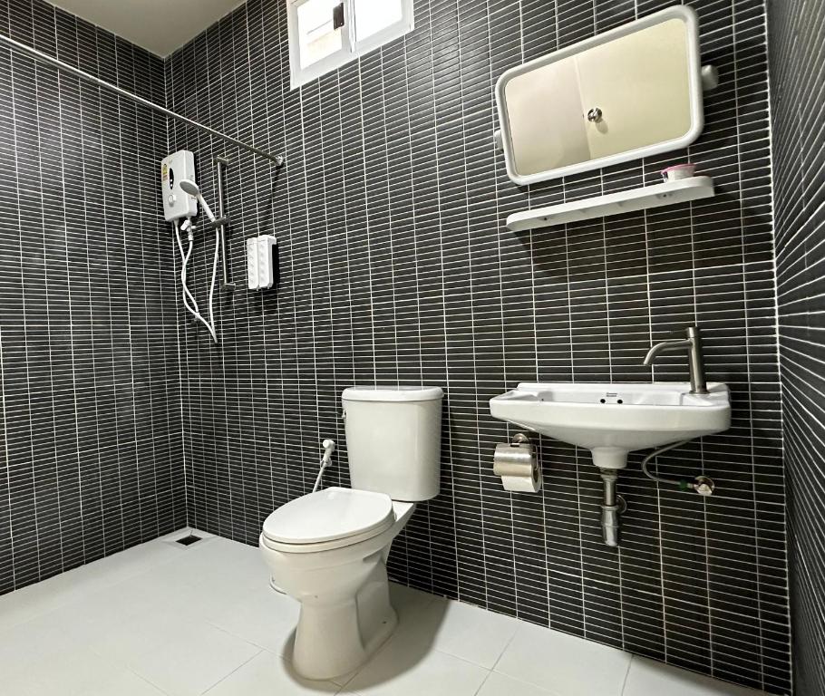 a bathroom with a toilet and a sink at Juni House Chumphon in Chumphon