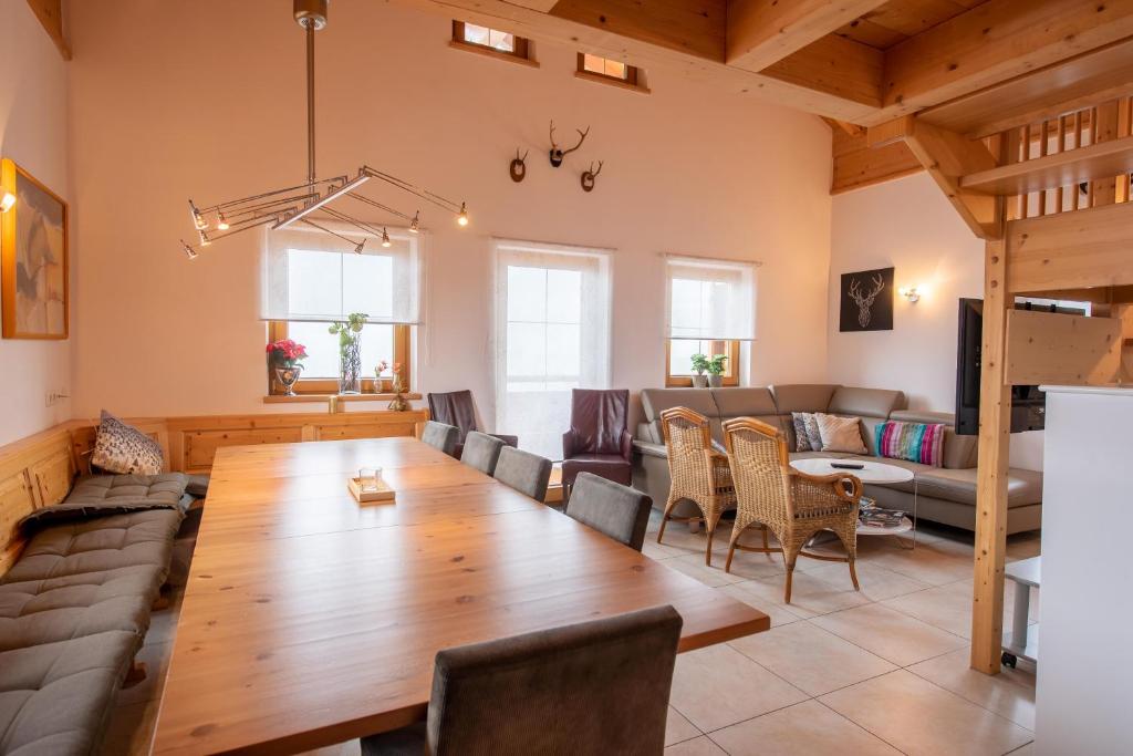 a living room with a large wooden table and chairs at Almhäuser Filzsteinalpe Almhaus 198 in Krimml