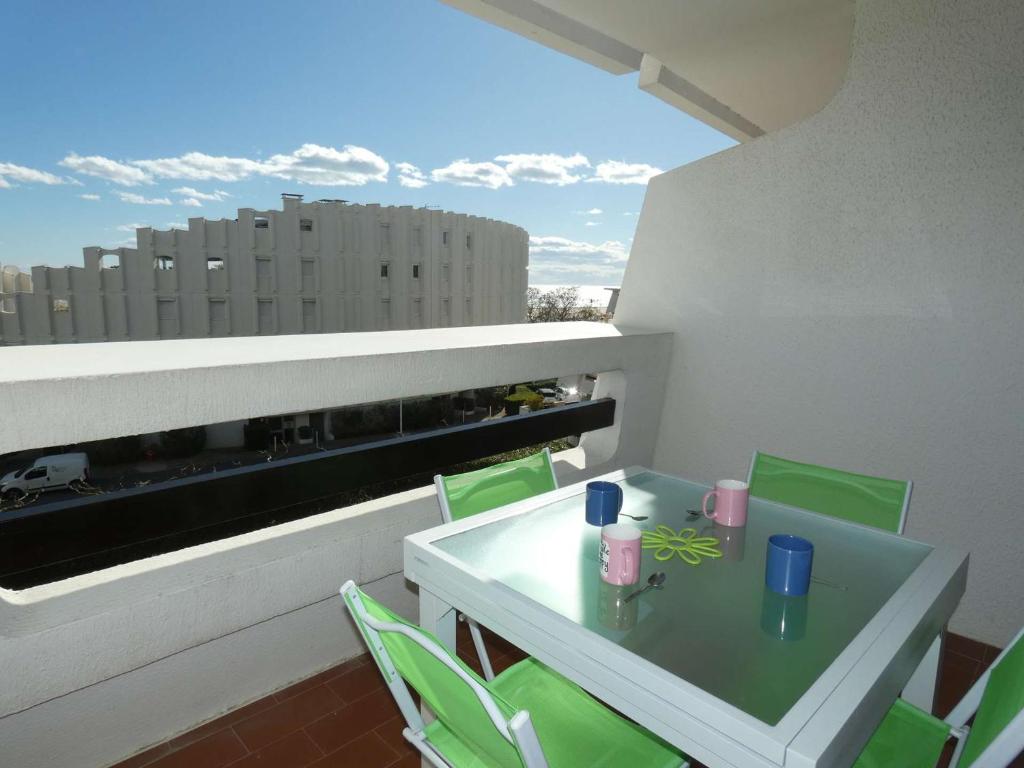 un balcon avec une table et des chaises sur un immeuble dans l'établissement Appartement 2 Pièces Cabine, Proche Plage, 5 Pers., Parking, Terrasse - FR-1-328-201, à La Grande Motte