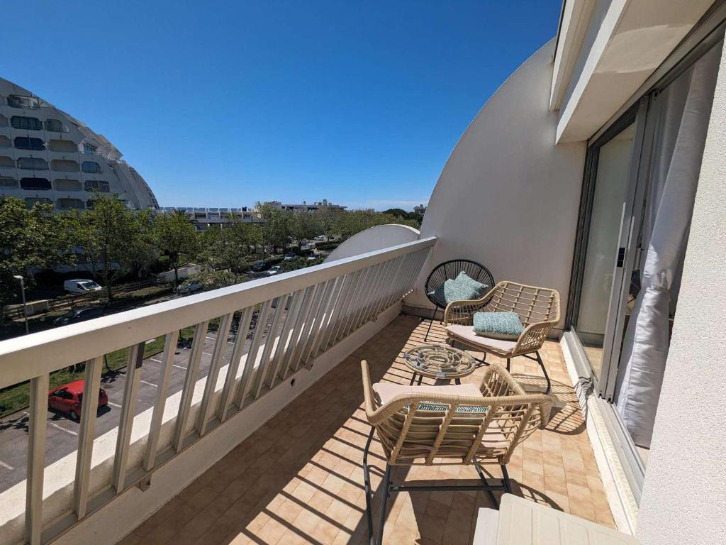 - un balcon avec deux chaises, une table et des chaises dans l'établissement Studio cabine rénové avec piscine, climatisation - La Grande-Motte - FR-1-250-271, à La Grande Motte