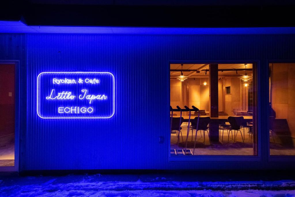 una señal azul en un lado de un restaurante con mesas en Little Japan Echigo en Yuzawa