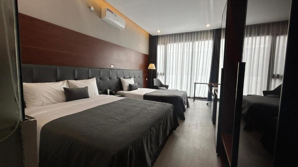 um quarto de hotel com duas camas e uma grande janela em Mango Hotel - Ha Noi Railway station em Hanói