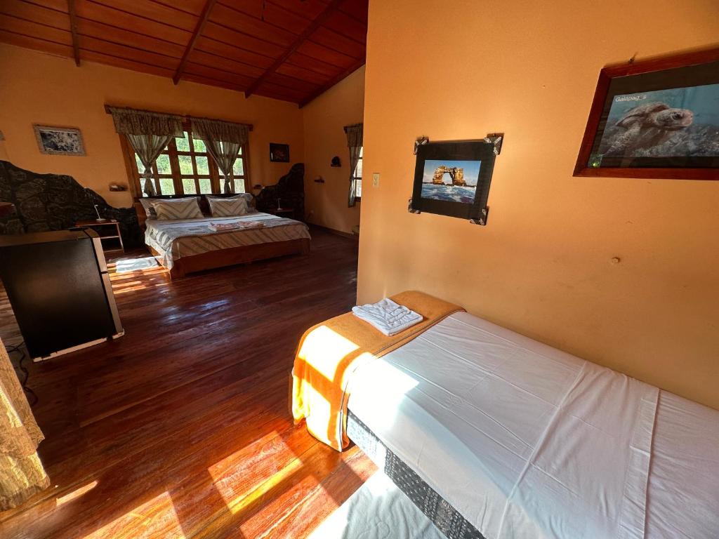 a bedroom with two beds and a living room at El Pajas in Puerto Velasco Ibarra
