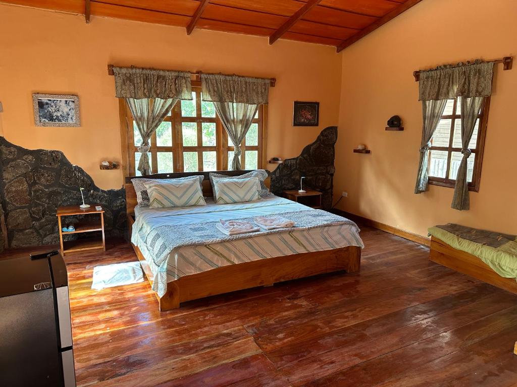 a bedroom with a bed in a room with wooden floors at El Pajas in Puerto Velasco Ibarra
