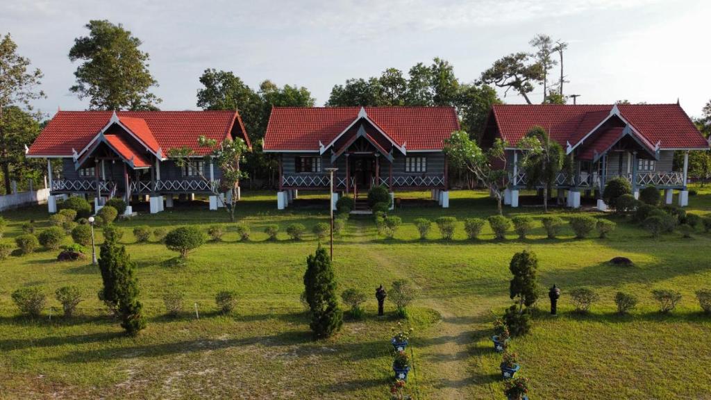 a house with red roofs on a green field at Nakai Resort in Ban Nakay Nua