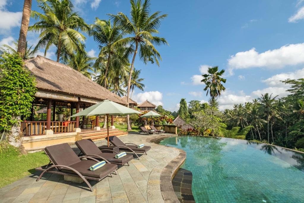 einen Pool in einem Resort mit Liegestühlen daneben in der Unterkunft Villa Semana Resort & Spa in Ubud