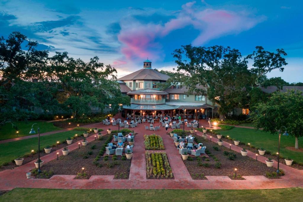 The Grand Hotel Golf Resort & Spa, Autograph Collection في Point Clear: مبنى به طاولات وكراسي في حديقة