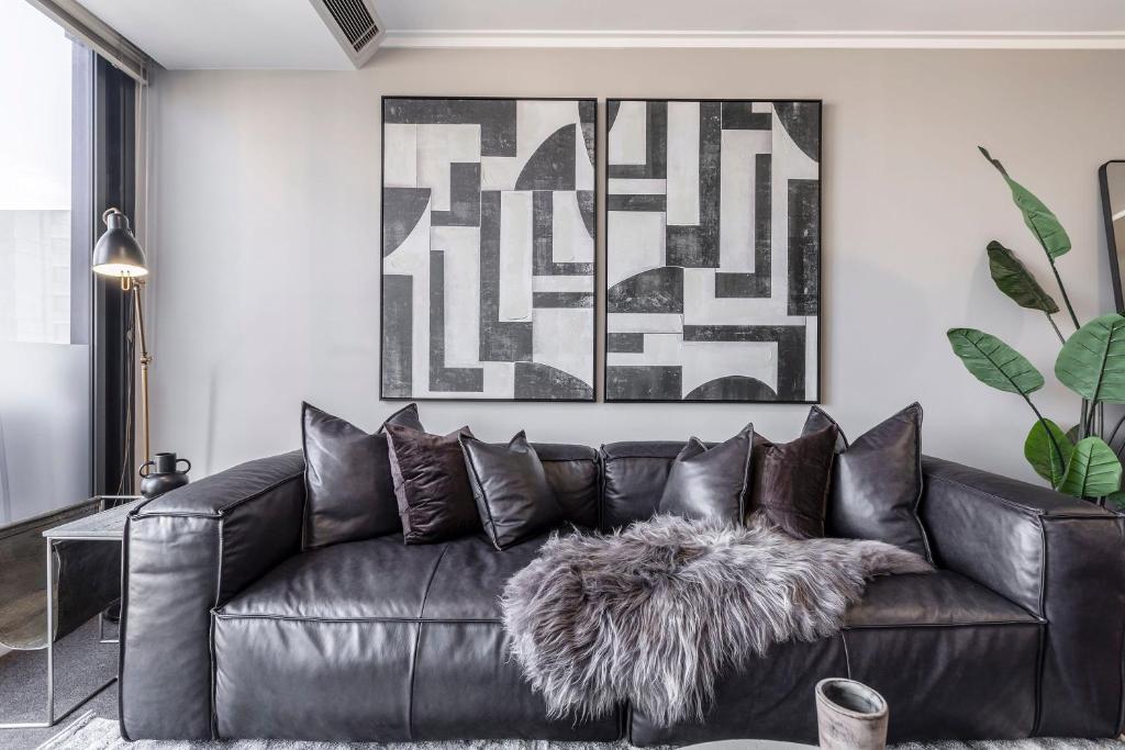 um sofá de couro preto numa sala de estar em VAQUAY Enigma In Southbank em Melbourne