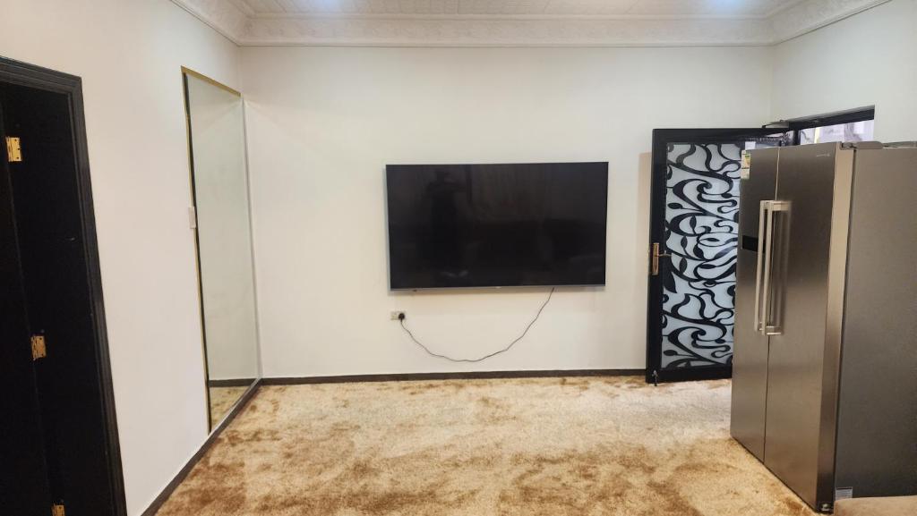 sala de estar con TV de pantalla plana en la pared en الجبيل, en Al Jubail