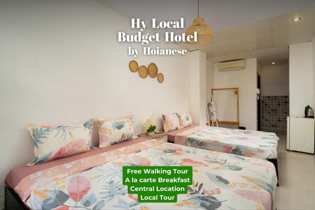 dos camas sentadas una al lado de la otra en una habitación en HY Local Budget Hotel by Hoianese - 5 mins walk to Hoi An Ancient Town en Hoi An