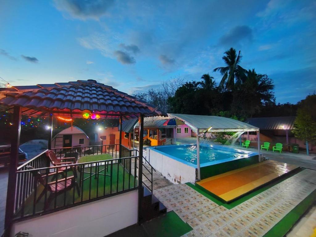 a swimming pool with a pavilion next to a house at Chemara Dusuntara Homestay in Jeniang