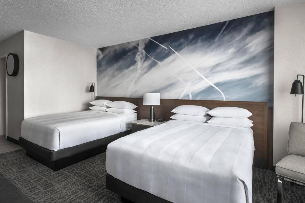a hotel room with two beds and a painting on the wall at Newark Liberty International Airport Marriott in Newark
