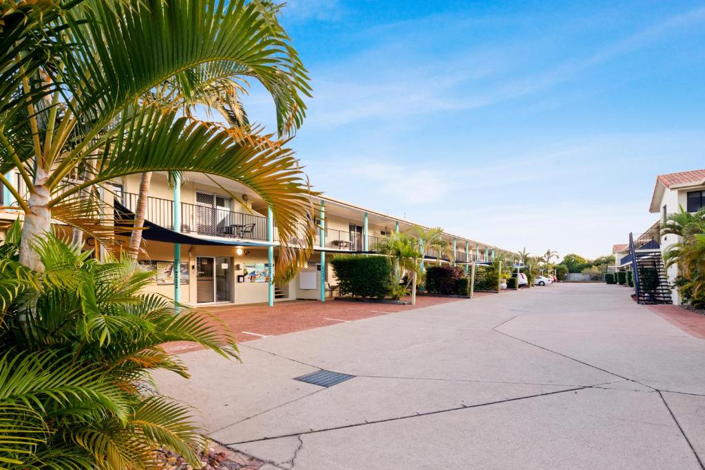 a palm tree in front of a building at Arlia Sands Apartments in Hervey Bay