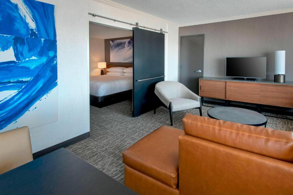 a hotel room with a couch and a bed at Newark Liberty International Airport Marriott in Newark