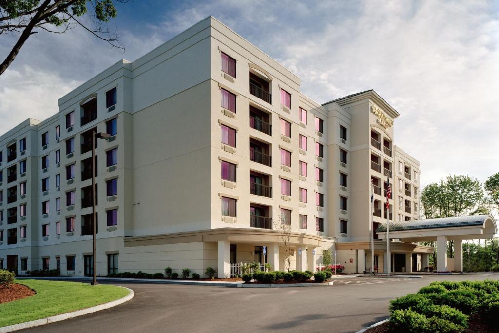 a large white building with pink windows at Courtyard Boston Natick in Natick