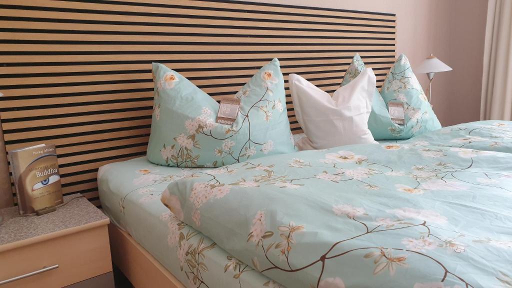 a bed with a blue comforter with flowers on it at Ferienwohnung Sonnenschein Familie Hamdorf in Bad Sulza