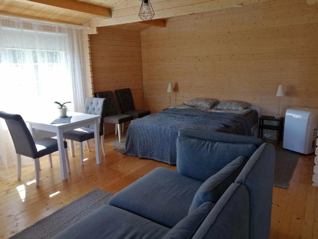 a bedroom with a bed and a table and chairs at Rangi Suvemaja in Hiiumaa