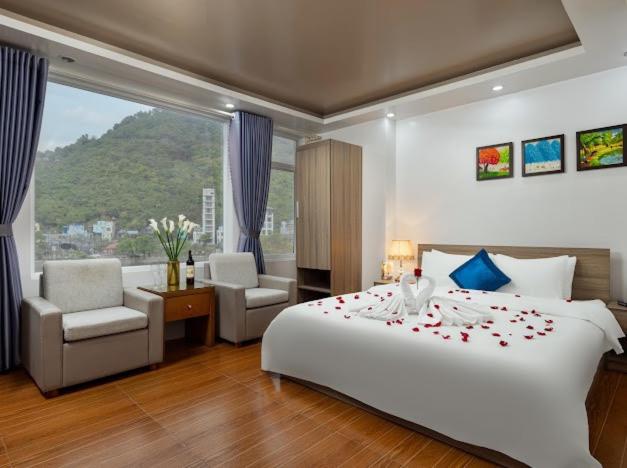um quarto com uma cama grande com rosas em Catba Central Hotel 2 em Ilha de Cát Bà