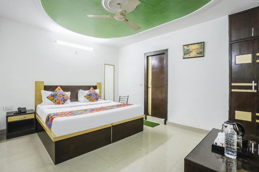 1 dormitorio con 1 cama y techo verde en FabHotel BR International en Agra