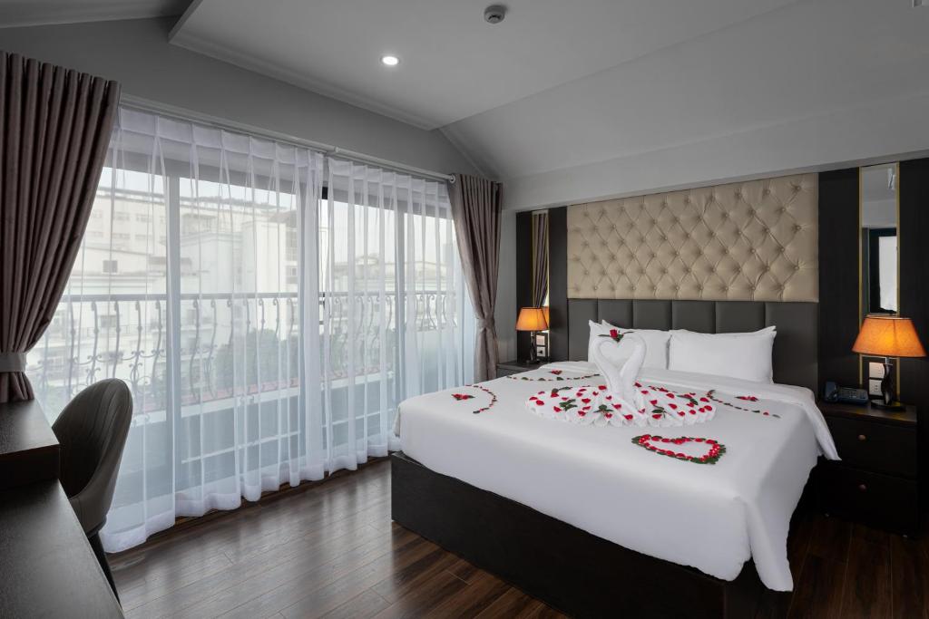 a bedroom with a large bed with red roses on it at Avani Central Hanoi Hotel in Hanoi