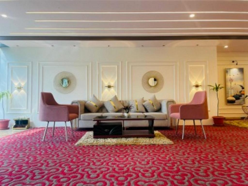 uma sala de estar com um sofá e duas cadeiras em VOVO HOTELS em Yelahanka