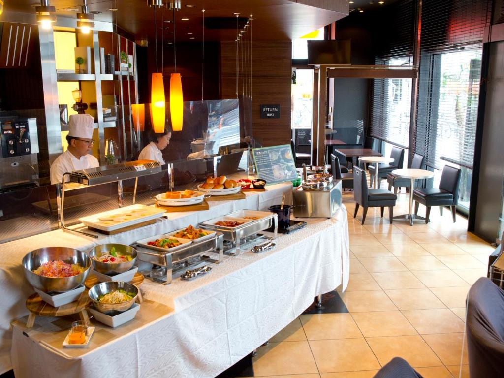 a buffet line in a restaurant with people preparing food at Hotel Hillarys in Osaka