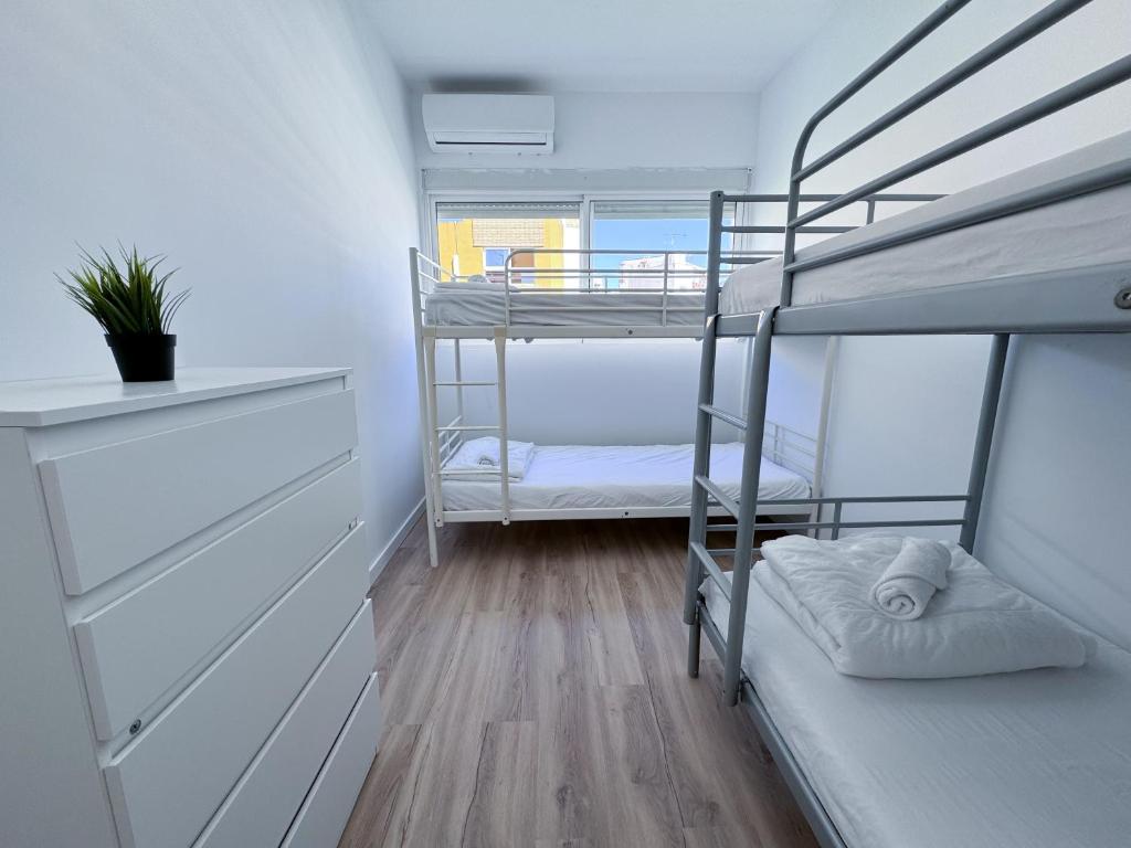 a room with two bunk beds and a wooden floor at Los Alcores 2.0 in Torremolinos