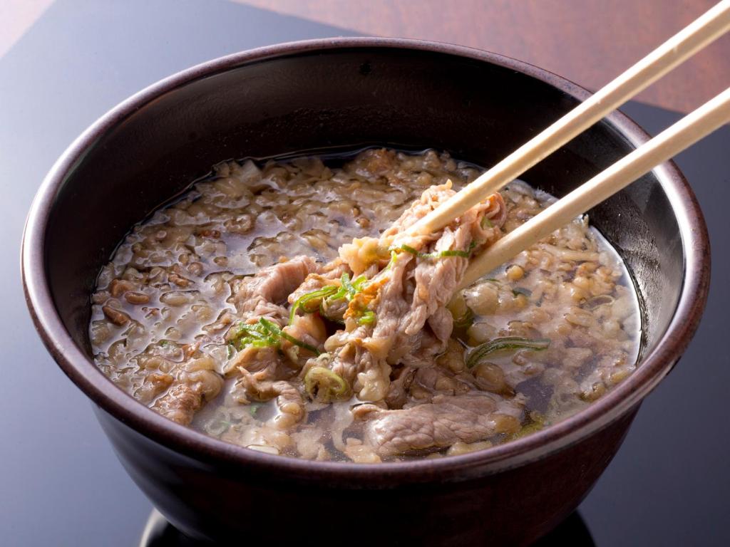 a bowl of food with meat and rice and chopsticks at Hotel Hillarys in Osaka