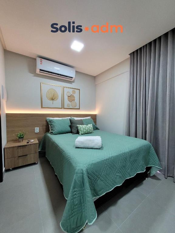 a bedroom with a bed with a green comforter at Way Bossa by Solis in João Pessoa