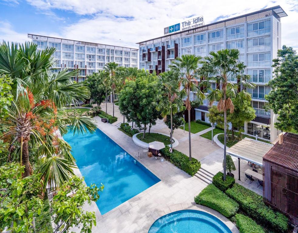 an aerial view of a hotel with a pool and palm trees at The Idle Hotel and Residence - SHA Plus Certified in Pathum Thani