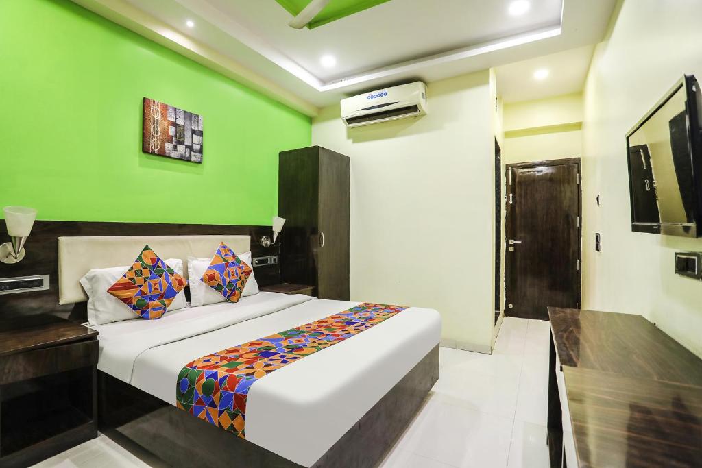 a bedroom with a bed with a green wall at FabHotel Starlight NX in Aurangabad