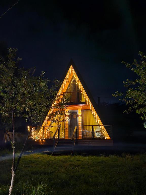 une cabane dans les arbres éclairée la nuit dans l'établissement B&B Cottage in Mestia, à Mestia