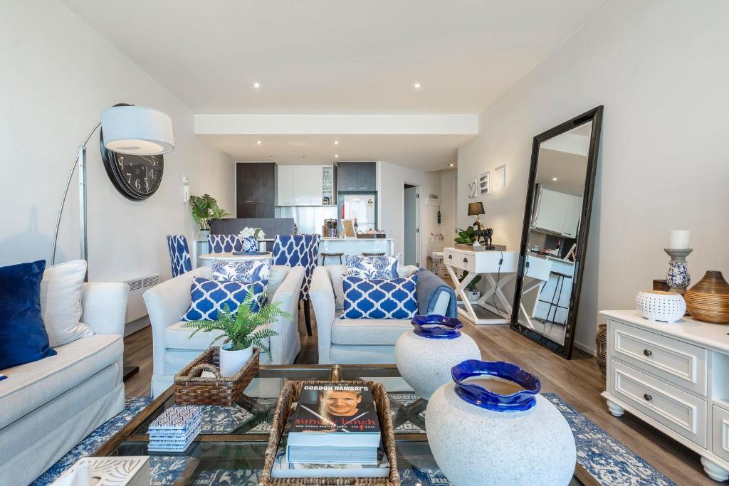 a living room with blue and white furniture at VAQUAY Glamptons In Docklands in Melbourne