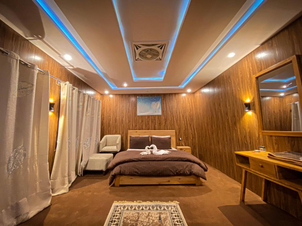 een slaapkamer met een bed met een blauw verlicht plafond bij Biafo House in Skardu