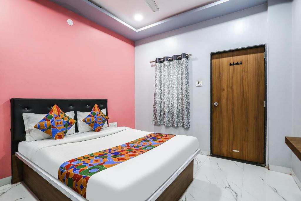 een slaapkamer met een bed en een houten deur bij FabHotel Carnival I in Aurangabad