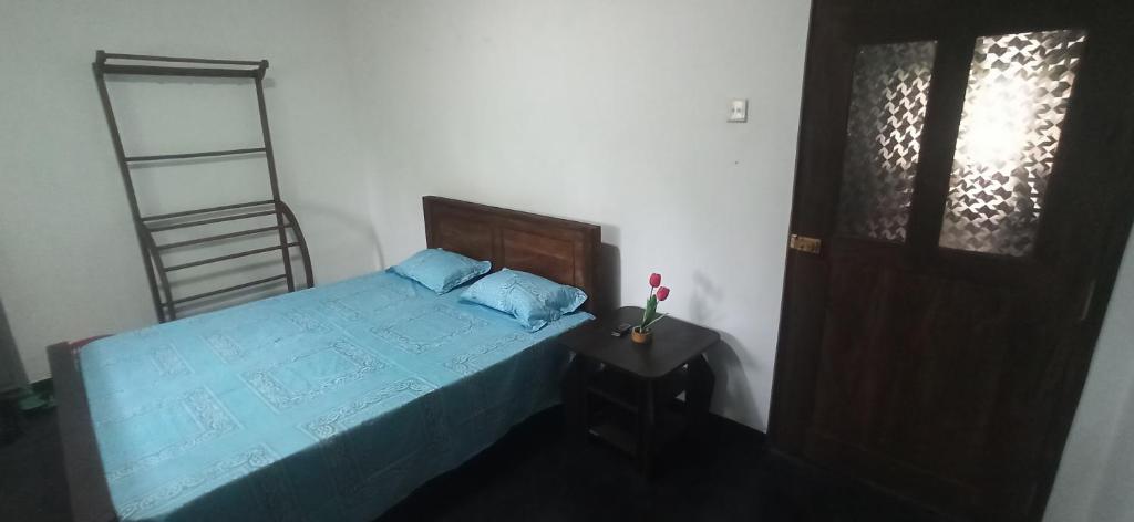 um quarto com uma cama com lençóis azuis e uma escada em Tamarind Ceylon Residence em Ambalantota