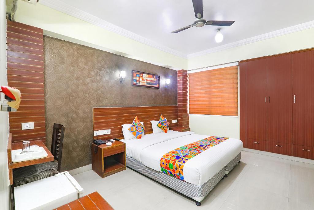 een slaapkamer met een groot wit bed en houten wanden bij FabHotel Royal Ville in Patna