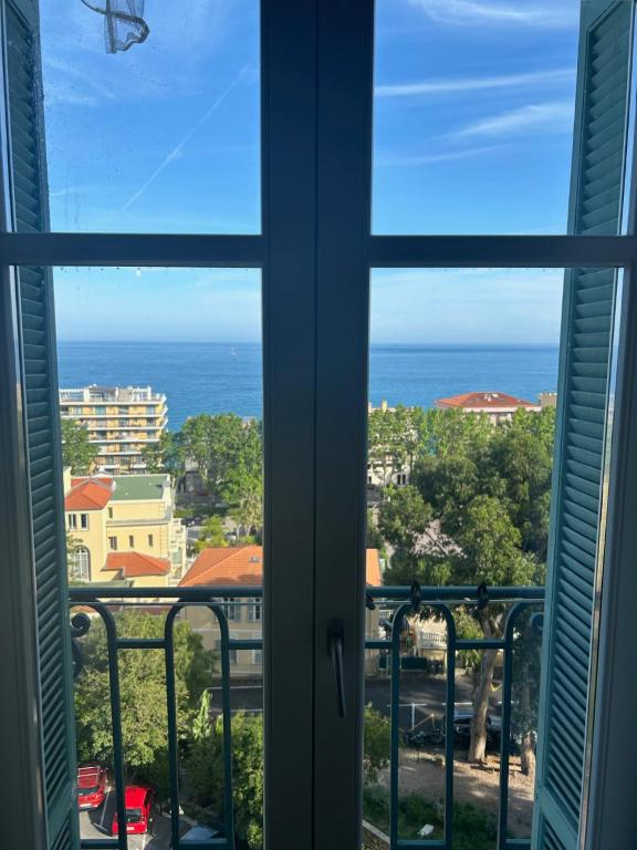 une vue sur l'océan depuis une fenêtre dans l'établissement Vaste 2 pièces raffiné vue mer MENTON CENTRE, à Menton