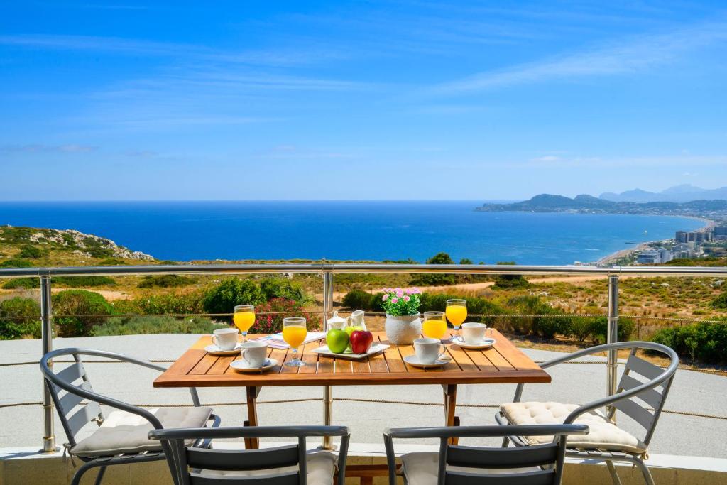 Rhodes Kallithea Villa - Zafira Private Pool Gem في كاليثيا رودس: طاولة مع الطعام والمشروبات على شرفة مع المحيط