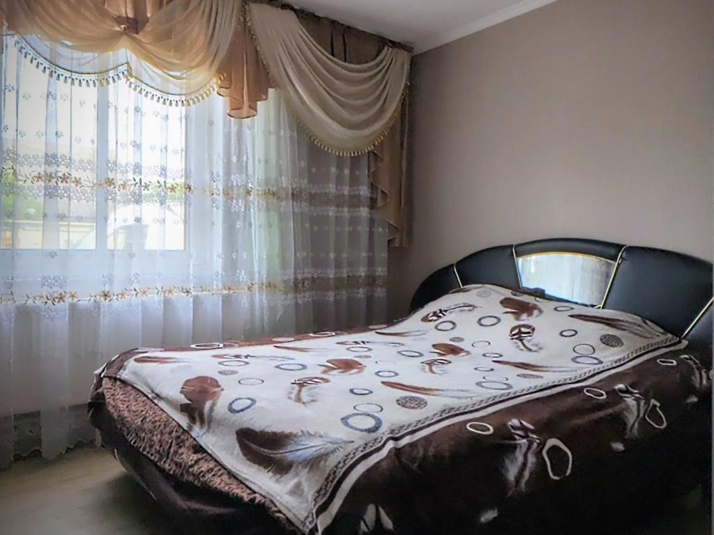 a bed in a room with a window at Частный дом in Bălţi