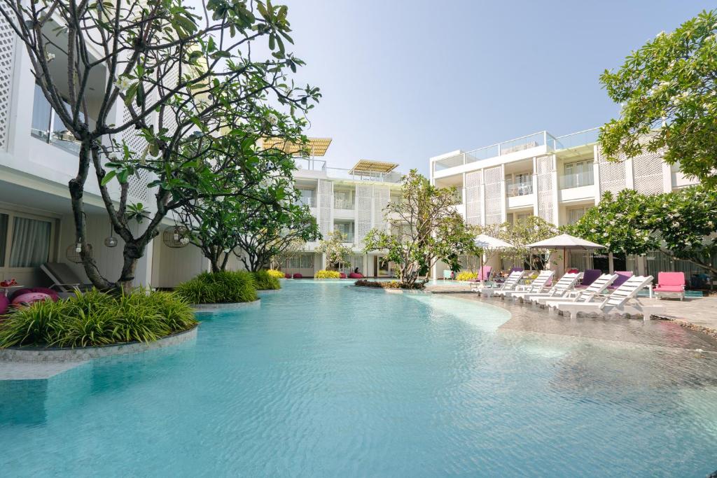 a swimming pool with chairs and a building at The Sea Cret Hua Hin in Hua Hin
