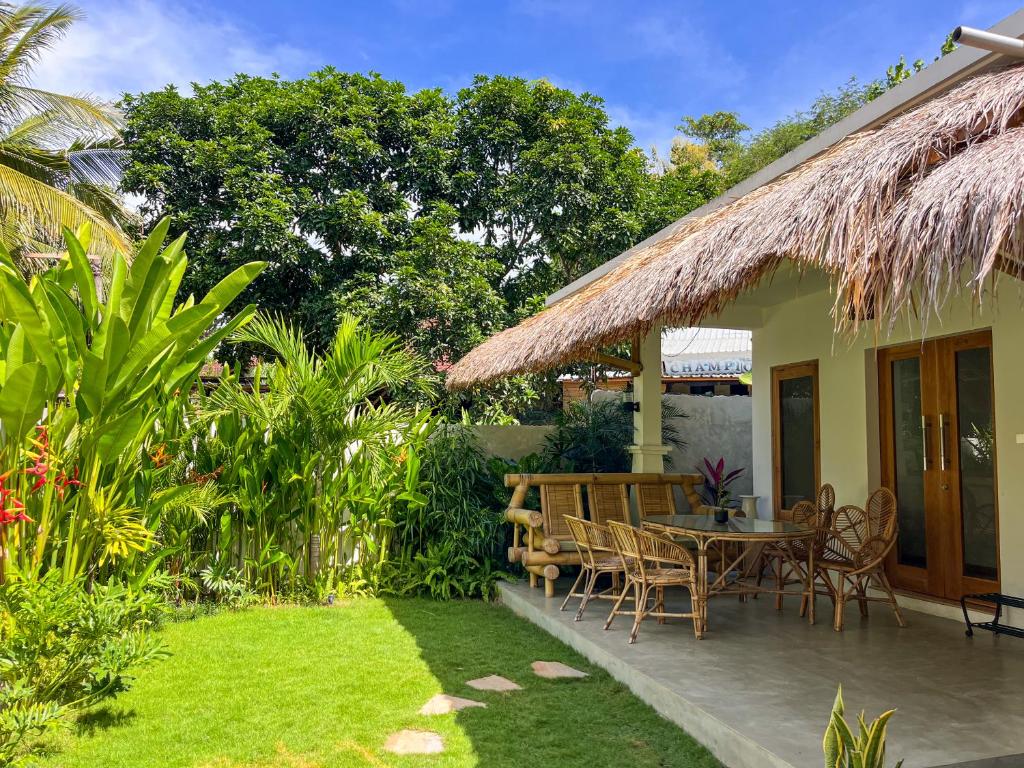 eine Terrasse mit einem Tisch und Stühlen im Garten in der Unterkunft Casa Flores in Kuta Lombok